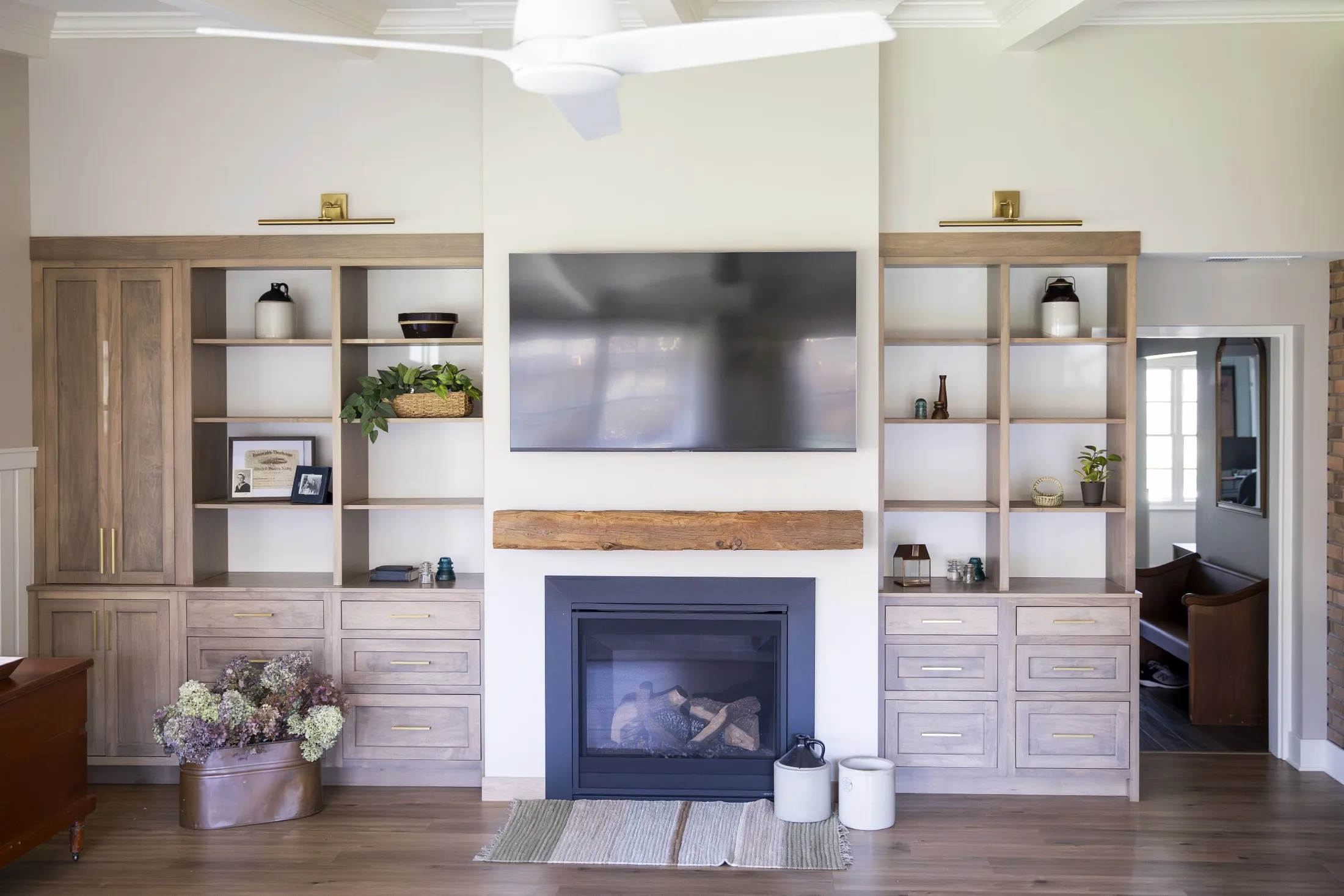 Weathered oak built-ins flanking a fireplace with reclaimed beam mantel