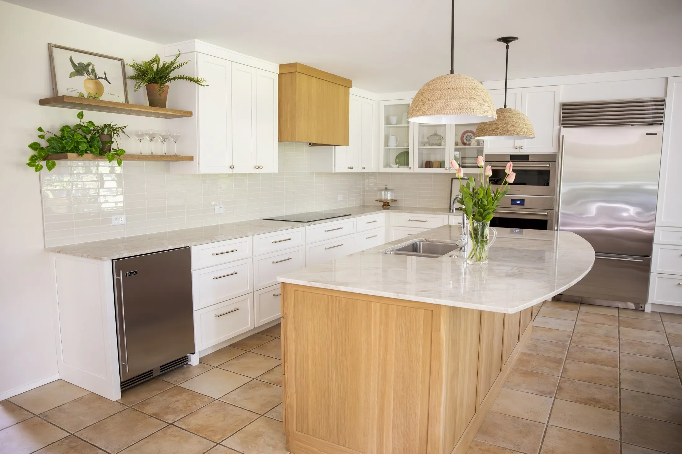White shaker kitchen with floating shelves, oak island and curved quartzite